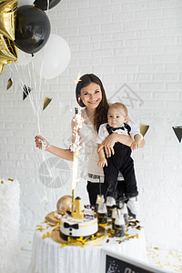 母亲和儿子一起庆祝一岁生日 带着气球笑着笑着 一个糖果棒 孩子 母性图片
