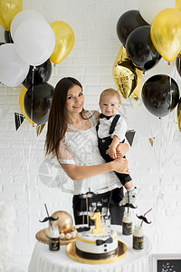 母亲和儿子一起庆祝一岁生日 带着气球笑着笑着 一个糖果棒 可爱的 美丽的图片