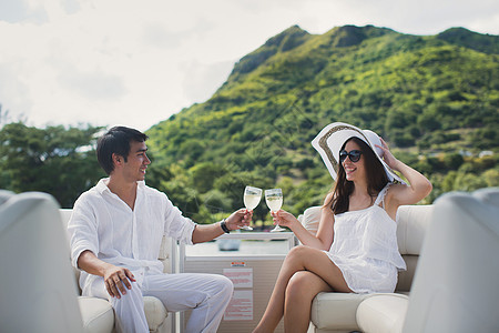 微笑的年轻夫妇拿着香槟酒杯 坐在游艇上看着对方 娱乐 毛里求斯图片