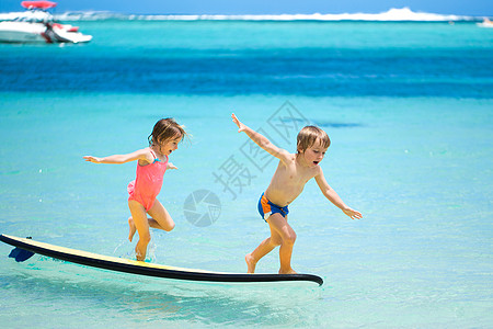 玩冲浪的孩子双胞胎兄妹在海中冲浪玩得开心 喜悦 冲浪板 水背景