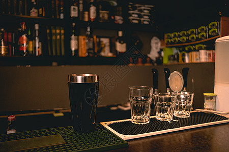 空杯子和鸡尾酒瓶 站在酒吧柜台上图片
