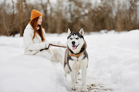 青年女子户外冬季 有狗玩的野外小狗图片