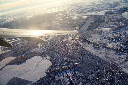 飞机起飞 飞行和旅行 在冬天的日落期间从机翼上的飞机窗口查看雪高清图片素材