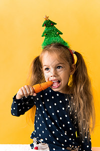 圣诞树装饰品Polka点礼服咬着吃橙色胡萝卜 新年 节日 庆典 冬季概念等活动都与庆祝和冬天的概念相提并论 小姑娘 牙齿图片