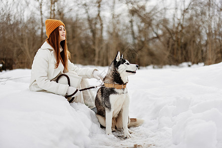 女人在雪雪中玩狗乐的游戏 友谊冬假图片