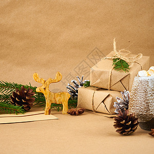 圣诞节和新年快乐零废牛皮纸背景 手工制作的圣诞礼物盒 冷杉树枝 热巧克力杯 棉花糖 侧视图 复制空间 环保无塑料概念图片