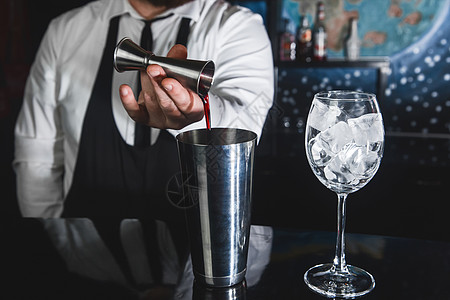 专业酒保的手把糖浆倒进一个测量杯子的抽筋器 装在金属工具中 用于准备和搅拌饮料酒精鸡尾酒和带冰块的眼镜 制作 水果图片