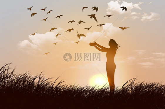 夕阳下草地上放飞鸽子的女人图片