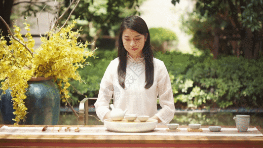 装在盘子里的饼干穿古风的女生品茶GIF高清图片