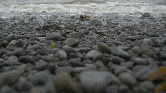 海浪冲上小石头海滩GIF图片