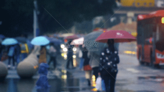 雨天大街上打伞骑自行车的路人GIF图片