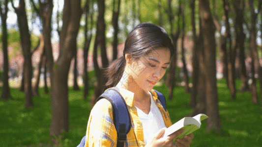 运动青年女生户外森林看指南书籍GIF高清图片