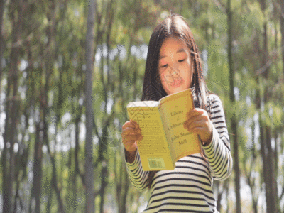 女孩站在草地上阅读GIF高清图片