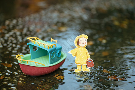 深秋在水洼里的玩具小船和小人图片