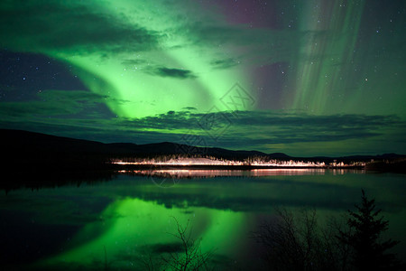 夜天星云和北极光在加拿大育空地区湖岸的乡图片