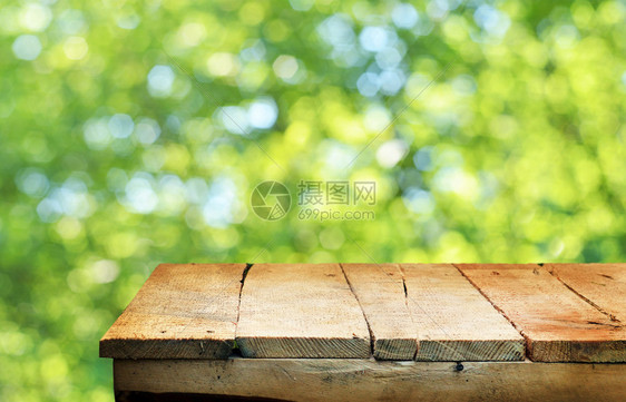 空桌子和散焦的新鲜绿色背景图片