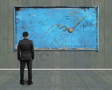商人在旧蓝色风化告示板上看商业概念图纸图片