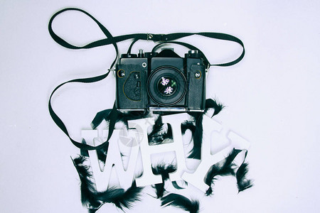以黑羽毛和模拟照相机覆盖的白色字母拼写出为什么用白字母制图片