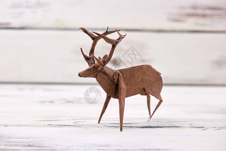 木制背景上的鹿雕像美丽的手工艺术折纸或折纸手工图片