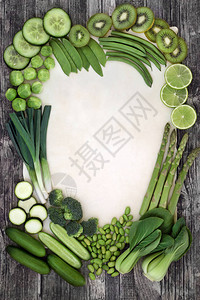 绿色蔬菜和水果超级食物选择在羊皮纸和质朴的木材背景上形成抽象边界富含抗氧化剂纤维生素和矿物质的图片