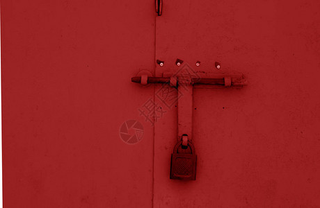 红色调金属门上的挂锁抽象背景和纹理背景图片