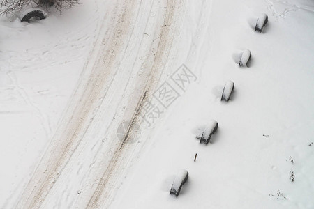白雪皑的道路旧轮子的围栏轮胎的栅栏带纹理的冬季背景抽象简约的雪天纹理脏雪中的汽车轨道从上面查看雪地上的人图片