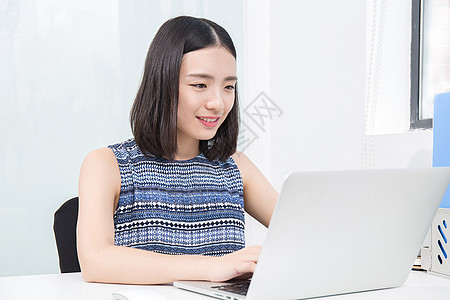 青年女性设计师操作笔记本电脑背景