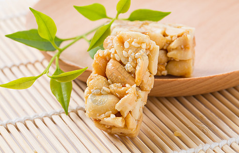 零食特写一块芝麻花生酥放在小木盘子上面背景