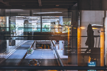机场窗前行走的旅客背景图片