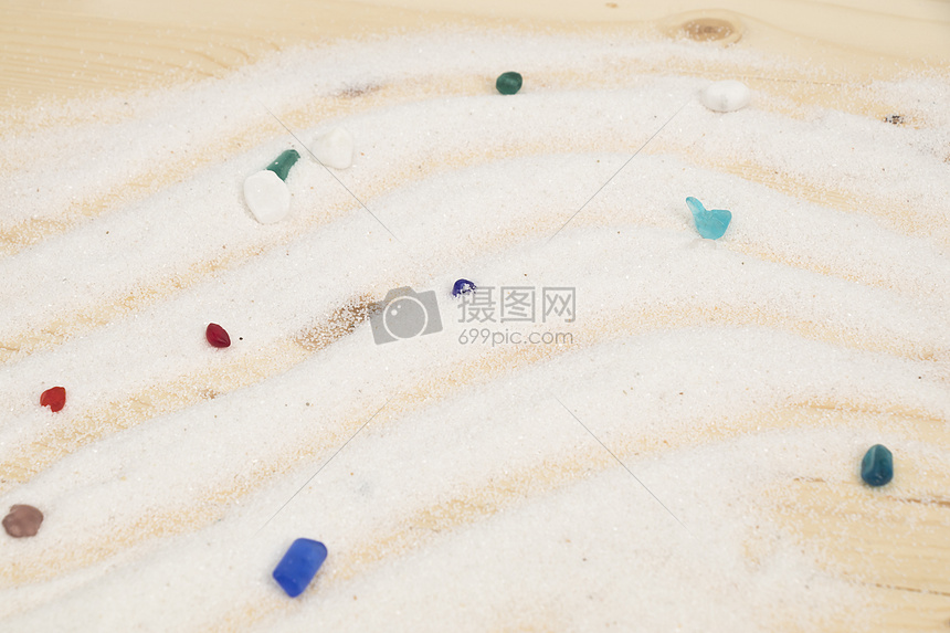 白色细沙上五彩缤纷的水晶图片