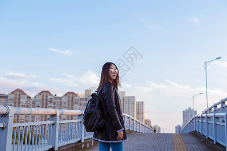 背包旅行墨镜女人帅气回头背景图片