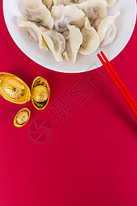 白盘子里的饺子中国冬至简洁红色喜庆背景的热饺子背景