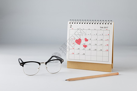情人节日历爱心眼镜铅笔在白色背景上图片