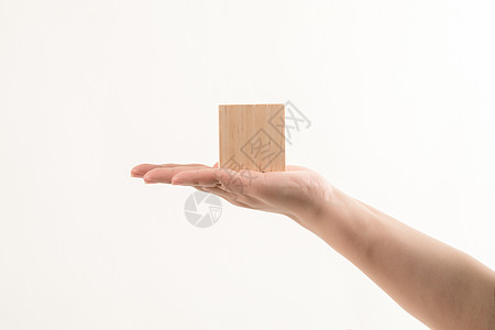 手拿立体几何正方体木头背景图片