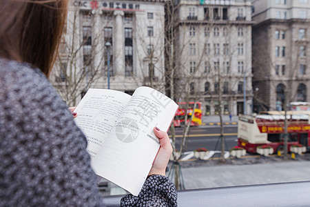 街头正在看书的美女可爱高清图片素材