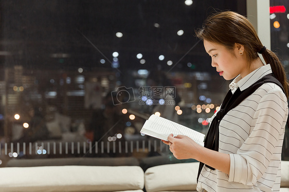 落地窗前夜晚女孩看书图片