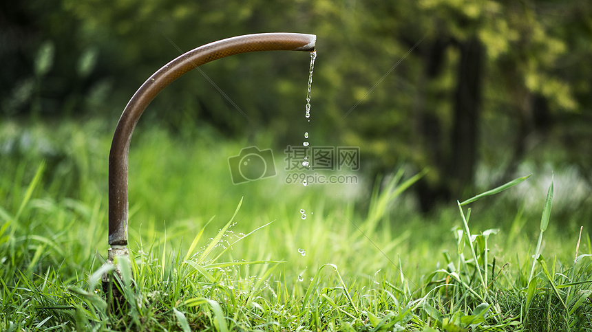 草坪里的水龙头滴水瞬间图片