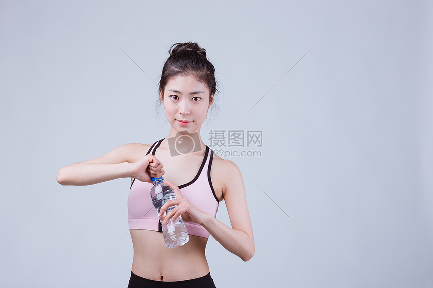 青春运动美女休息拿矿泉水图片