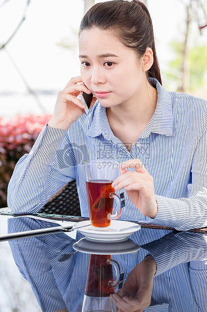 年轻女子在咖啡馆打电话图片