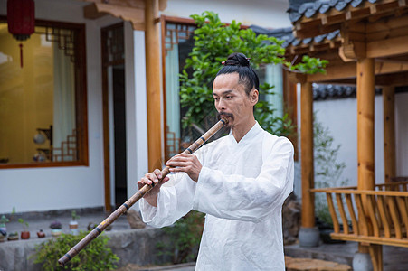 白衣天使在人间一位白衣道士在庭院内吹奏长笛背景