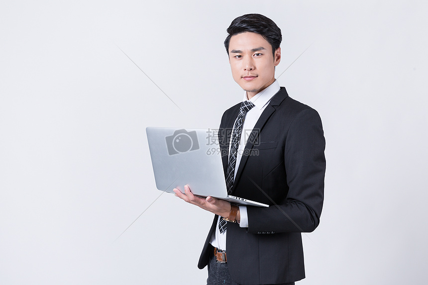 商务人士手托笔记本电脑图片