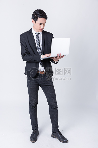 商务人士手托笔记本电脑图片