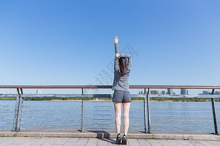 健身性感美女运动女孩阳光下拉伸身体背景