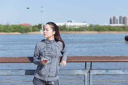 皇后大道运动女孩靠栏杆休息听音乐背景