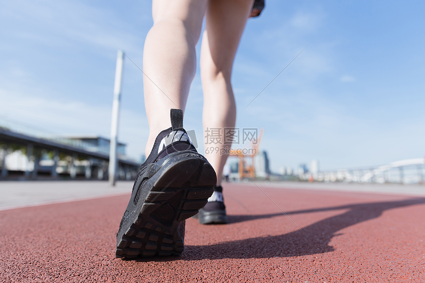 阳光下运动女孩跑道上走路图片