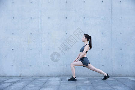 运动女模特户外运动女孩热身压腿背景