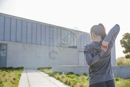 户外健身美女傍晚运动美女拉伸身体背影背景