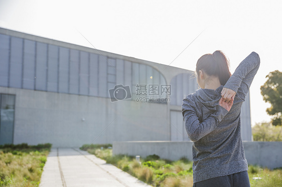 傍晚运动美女拉伸身体背影