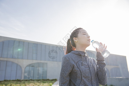 女孩开心喝水落日运动女孩休息喝水背景