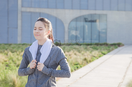 落日运动女孩挂着毛巾休息图片